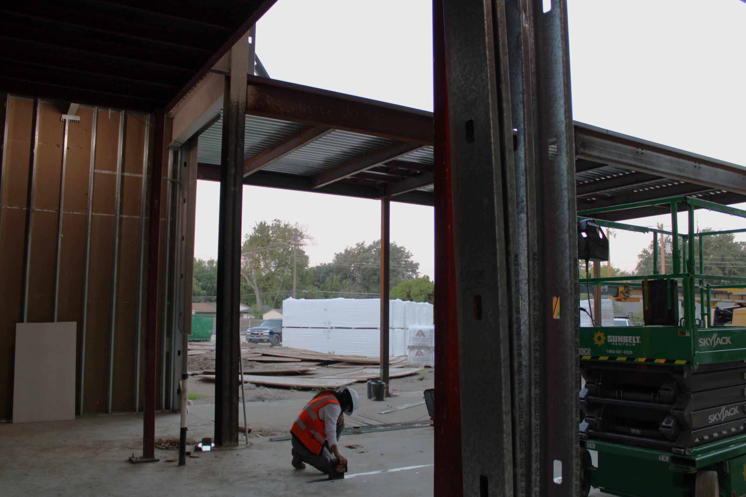 Construction Worker Standing on Metal Beams With Blue Sky In The Background